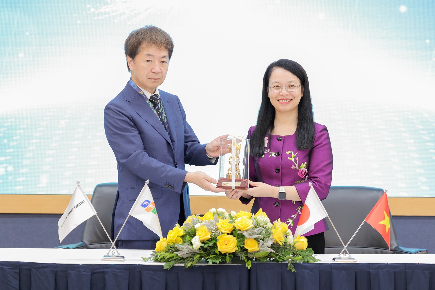 Chủ tịch FPT Software Chu Thị Thanh Hà trao quà tặng là biểu tượng mã gen của người FPT cho đại diện Nippon Seiki.