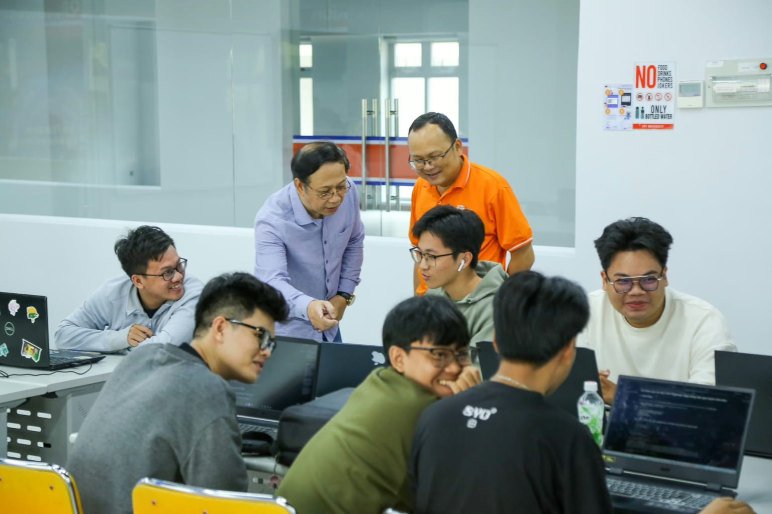 Ông Satomura Shinichi (áo sơ mi xanh) – Giám đốc điều hành Valley Campus Sài Gòn và thầy Phạm Thanh Trí (áo cam) – Giảng viên Kỹ thuật phần mềm thảo luận cùng nhóm sinh viên thực hiện dự án