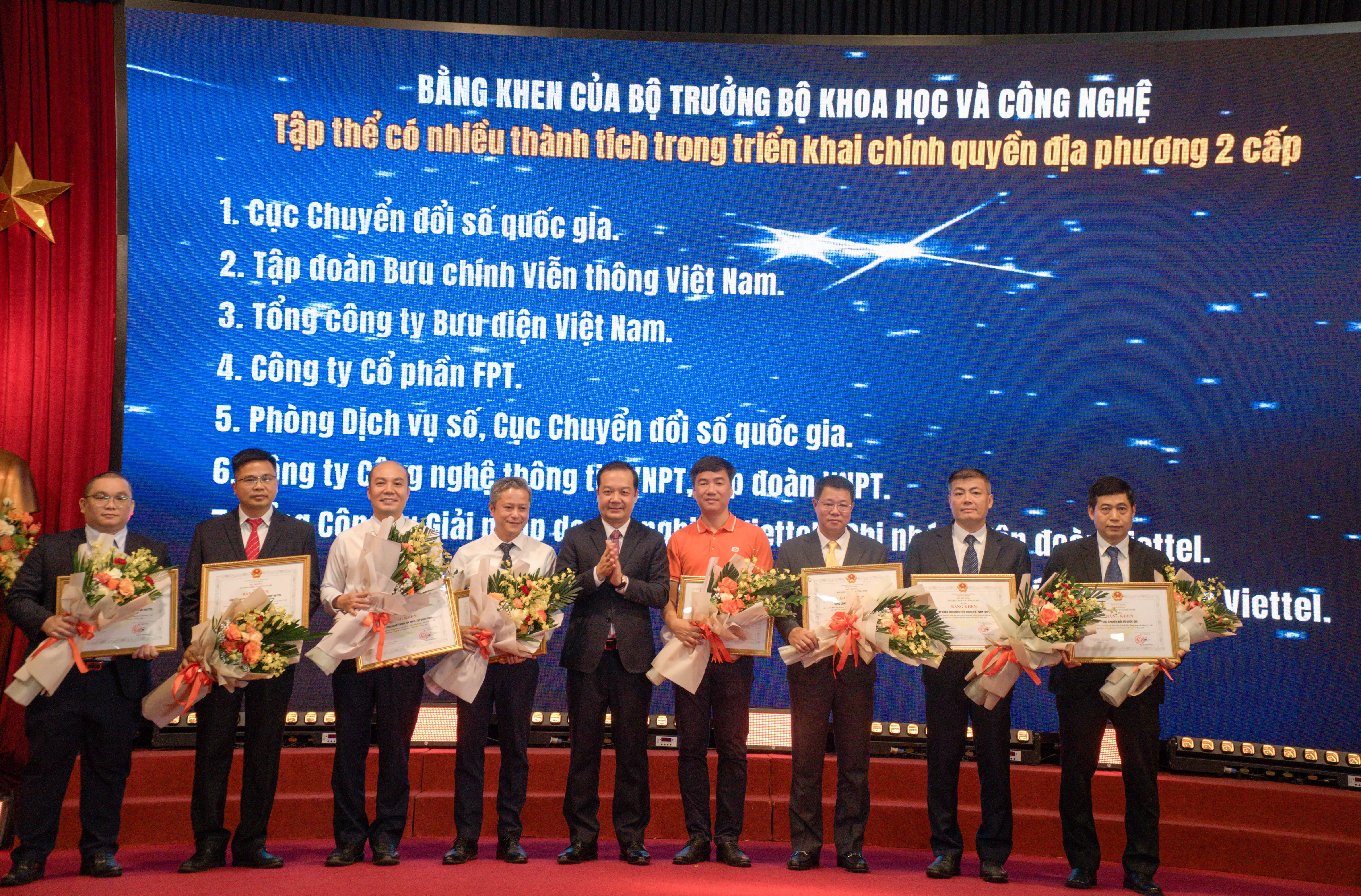 FPT representative (in orange) receives the Certificate of Merit from the Minister of Science and Technology for the company’s contributions to transforming critical IT systems supporting the operation of the Two-Tier Government Model.